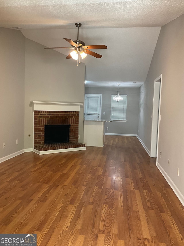 233 Winterville, Rockmart, GA 30153 - unfurnished living room with a ceiling fan, dark wood-style floors, a fireplace, and vaulted ceiling