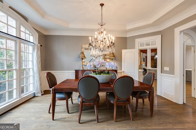 314 Caruso Ct, Sandy Springs, GA 30350 - dining space featuring a chandelier, a raised ceiling, wood finished floors, wainscoting, and crown molding