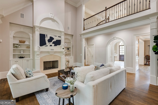 314 Caruso Ct, Sandy Springs, GA 30350 - living area with dark wood-style flooring, a high ceiling, a tile fireplace, ornamental molding, and built in shelves