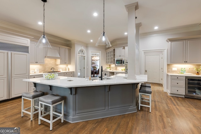 314 Caruso Ct, Sandy Springs, GA 30350 - kitchen with beverage cooler, built in appliances, decorative backsplash, light countertops, and ornamental molding