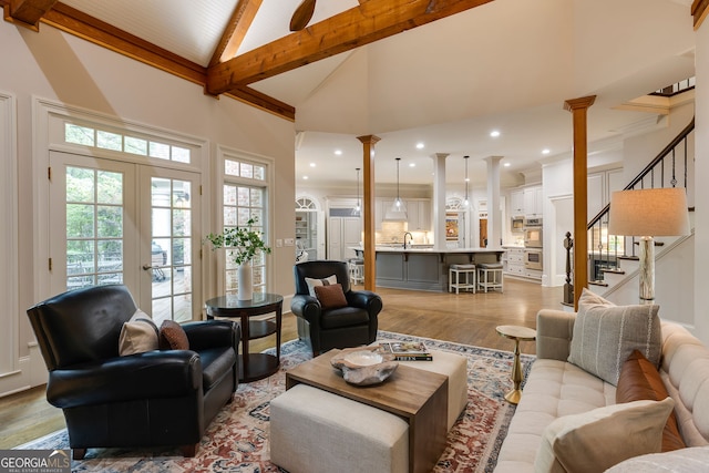 314 Caruso Ct, Sandy Springs, GA 30350 - living room with light wood finished floors, high vaulted ceiling, beam ceiling, ornate columns, and stairs