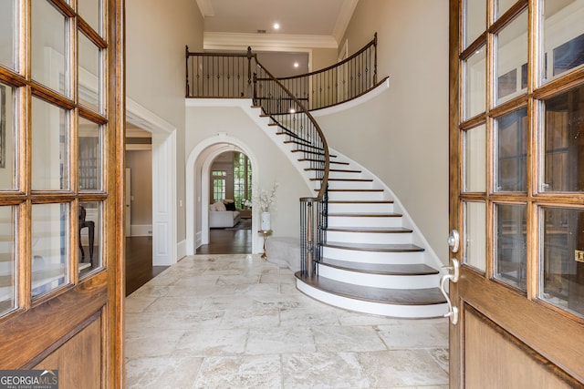 314 Caruso Ct, Sandy Springs, GA 30350 - foyer featuring stone tile flooring, a high ceiling, ornamental molding, stairs, and arched walkways