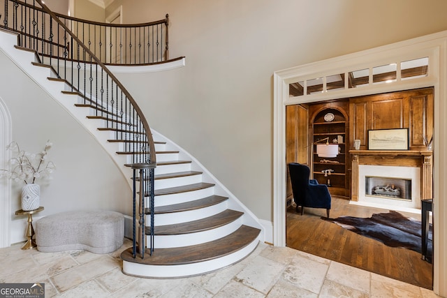 314 Caruso Ct, Sandy Springs, GA 30350 - stairway with built in shelves, a fireplace, a high ceiling, and stone tile flooring