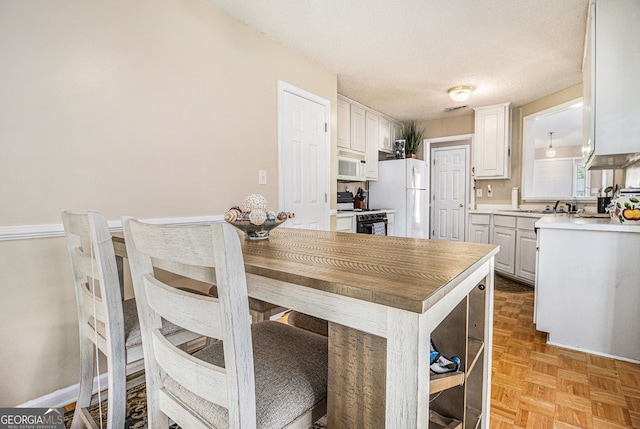 7008 Glen Valley Way, Fairburn, GA 30213 - kitchen featuring white appliances, white cabinetry, a peninsula, light countertops, and a textured ceiling