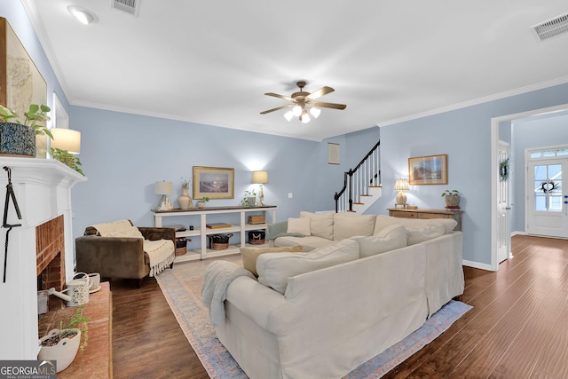 4218 Sandy Branch Dr, Buford, GA 30519 - living room featuring a fireplace, dark wood-style flooring, stairs, a ceiling fan, and crown molding