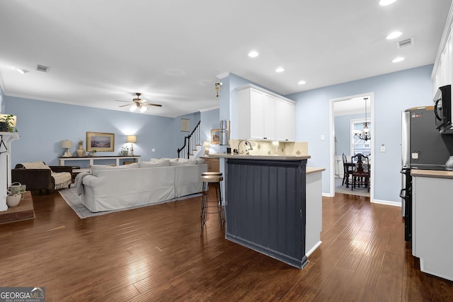 4218 Sandy Branch Dr, Buford, GA 30519 - kitchen featuring white cabinetry, a breakfast bar area, dark wood-style flooring, ceiling fan, and backsplash