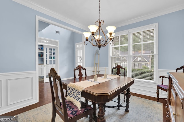 4218 Sandy Branch Dr, Buford, GA 30519 - dining room featuring ornamental molding, a wainscoted wall, wood finished floors, a chandelier, and healthy amount of natural light