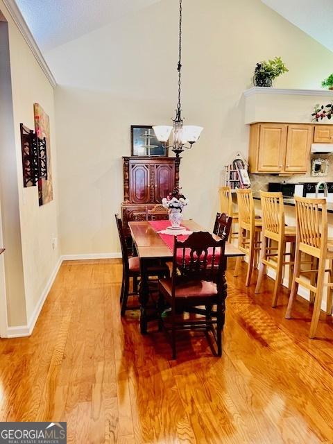 1535 Duluth Hwy Unit 1101, Lawrenceville, GA 30043 - dining area featuring a chandelier, high vaulted ceiling, light wood-style floors, and baseboards
