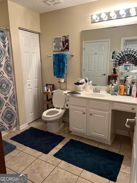 1535 Duluth Hwy Unit 1101, Lawrenceville, GA 30043 - bathroom with vanity, tile patterned flooring, a textured ceiling, a closet, and toilet