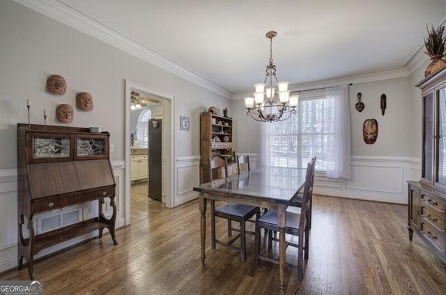 5327 Saville Dr NW, Acworth, GA 30101 - dining area with a chandelier, wainscoting, wood finished floors, ornamental molding, and a decorative wall
