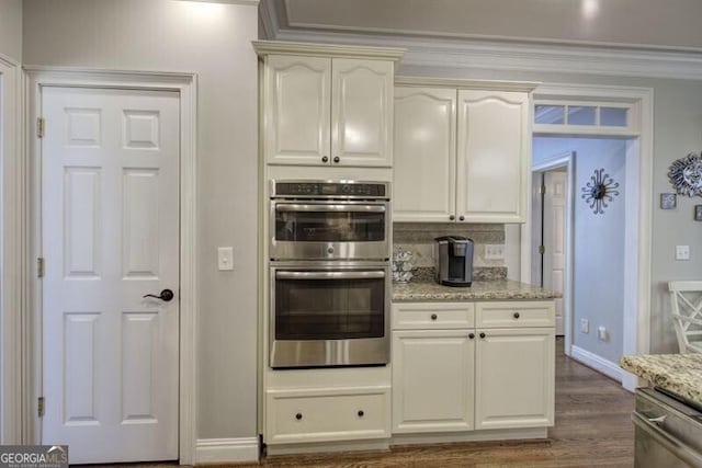 5327 Saville Dr NW, Acworth, GA 30101 - kitchen with appliances with stainless steel finishes, light stone countertops, dark wood-style flooring, crown molding, and decorative backsplash