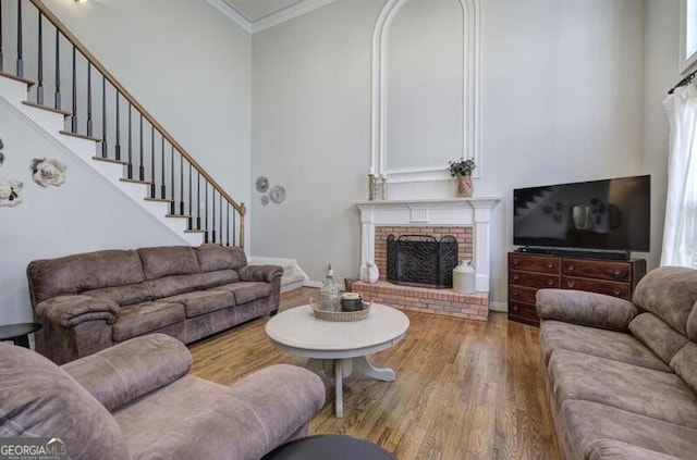 5327 Saville Dr NW, Acworth, GA 30101 - living room with wood finished floors, a brick fireplace, ornamental molding, a towering ceiling, and stairway