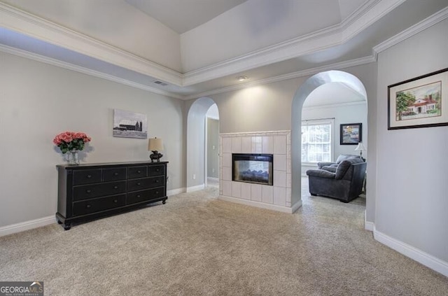 5327 Saville Dr NW, Acworth, GA 30101 - living room featuring a tiled fireplace, carpet, arched walkways, and crown molding