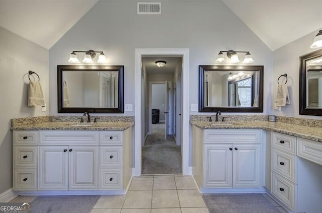 5327 Saville Dr NW, Acworth, GA 30101 - bathroom with vaulted ceiling, two vanities, and tile patterned floors