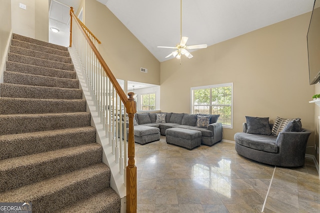 5125 Winding Glen Dr, Lithonia, GA 30038 - living room featuring stairs, a ceiling fan, stone tile flooring, high vaulted ceiling, and baseboards