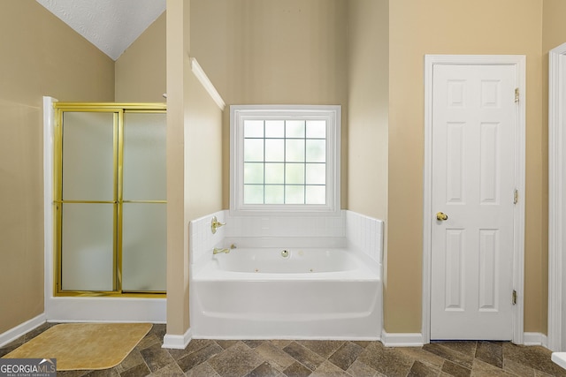 5125 Winding Glen Dr, Lithonia, GA 30038 - bathroom featuring a stall shower, a whirlpool tub, vaulted ceiling, and baseboards