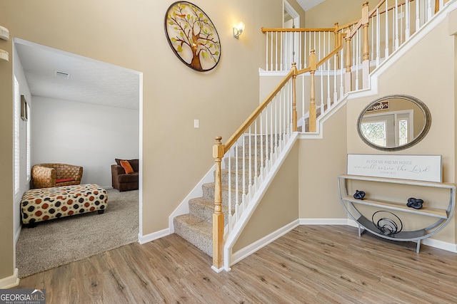 5125 Winding Glen Dr, Lithonia, GA 30038 - stairs featuring wood finished floors, baseboards, and a towering ceiling