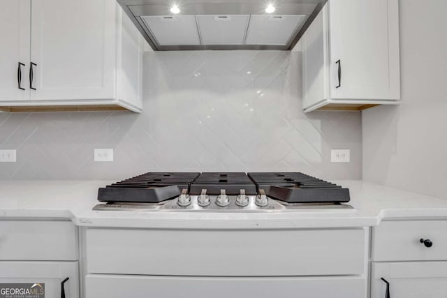 6775 Cambridge Dr, Flowery Branch, GA 30542 - kitchen featuring wall chimney range hood, white cabinetry, decorative backsplash, stainless steel gas cooktop, and light stone countertops