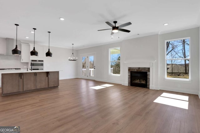 6775 Cambridge Dr, Flowery Branch, GA 30542 - unfurnished living room featuring a fireplace, a ceiling fan, recessed lighting, light wood finished floors, and baseboards