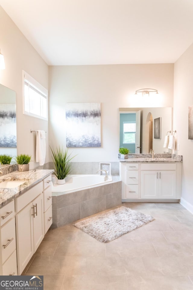 2665 Crowbrook Way, Cumming, GA 30040 - bathroom featuring healthy amount of natural light, two vanities, tile patterned floors, and a bath
