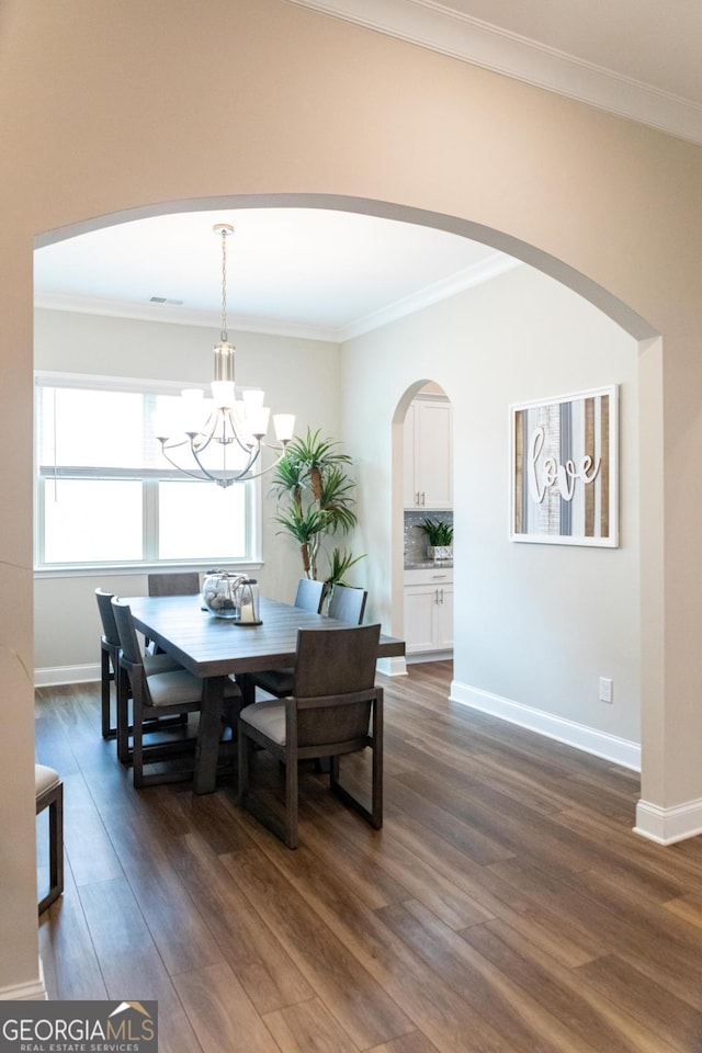 2665 Crowbrook Way, Cumming, GA 30040 - dining space featuring dark wood-style flooring, arched walkways, a chandelier, and ornamental molding