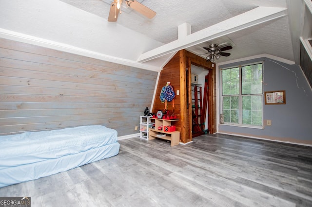 258 Big Oak Rd, Whitesburg, GA 30185 - bedroom with vaulted ceiling, a textured ceiling, wood finished floors, wooden walls, and ceiling fan