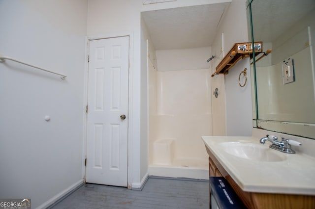258 Big Oak Rd, Whitesburg, GA 30185 - bathroom with vanity, baseboards, a stall shower, wood finished floors, and a textured ceiling