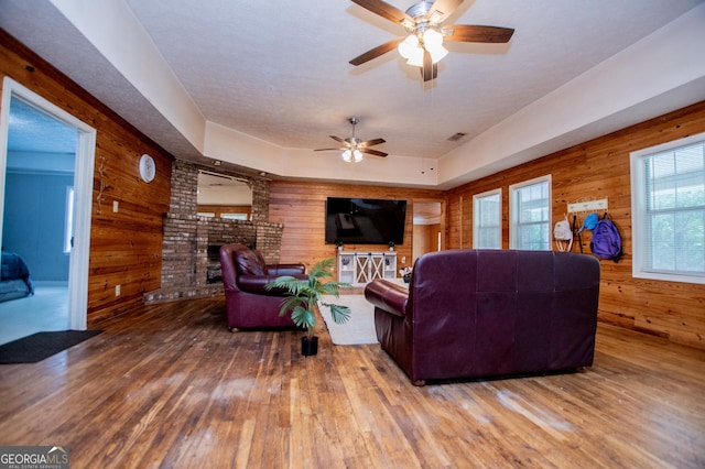 258 Big Oak Rd, Whitesburg, GA 30185 - living area featuring wood walls, ceiling fan, a fireplace, and wood-type flooring