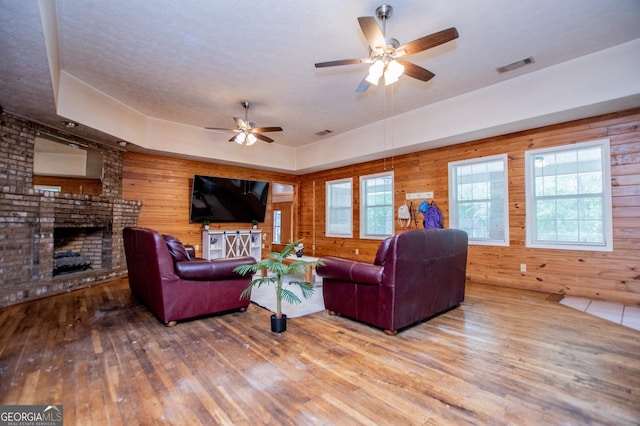258 Big Oak Rd, Whitesburg, GA 30185 - living room with a ceiling fan, wooden walls, hardwood / wood-style floors, and a fireplace
