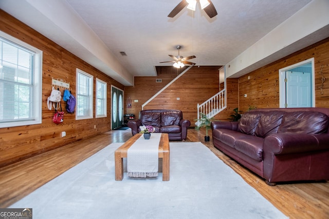 258 Big Oak Rd, Whitesburg, GA 30185 - living area with wood walls, wood finished floors, ceiling fan, and stairs