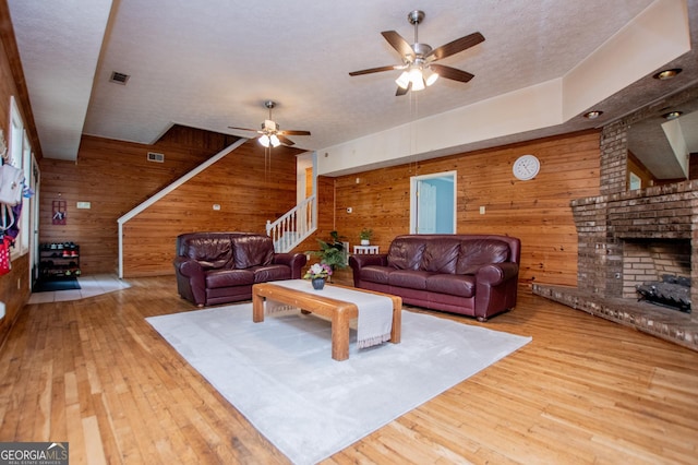 258 Big Oak Rd, Whitesburg, GA 30185 - living area with wooden walls, ceiling fan, hardwood / wood-style floors, a fireplace, and stairway