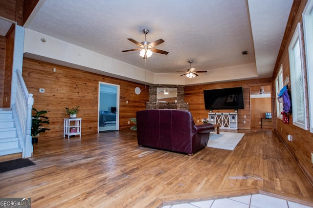 258 Big Oak Rd, Whitesburg, GA 30185 - living area with wood walls, hardwood / wood-style floors, ceiling fan, and stairway