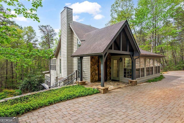 1573 Sautee Trl, Sautee Nacoochee, GA 30571 - view of front of house with a sunroom, a shingled roof, and a chimney