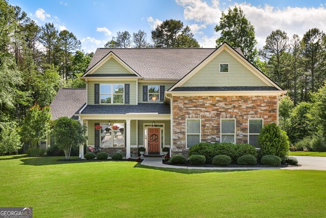 372 Abbington Way, Clarkesville, GA 30523 - craftsman-style house featuring a front lawn, a shingled roof, stone siding, and covered porch
