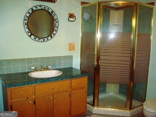 697 Waddell Rd, Woodbury, GA 30293 - bathroom featuring vanity, a shower stall, toilet, and tasteful backsplash