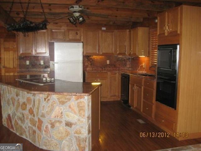 697 Waddell Rd, Woodbury, GA 30293 - kitchen with freestanding refrigerator, tasteful backsplash, dark wood-style flooring, ceiling fan, and a kitchen island