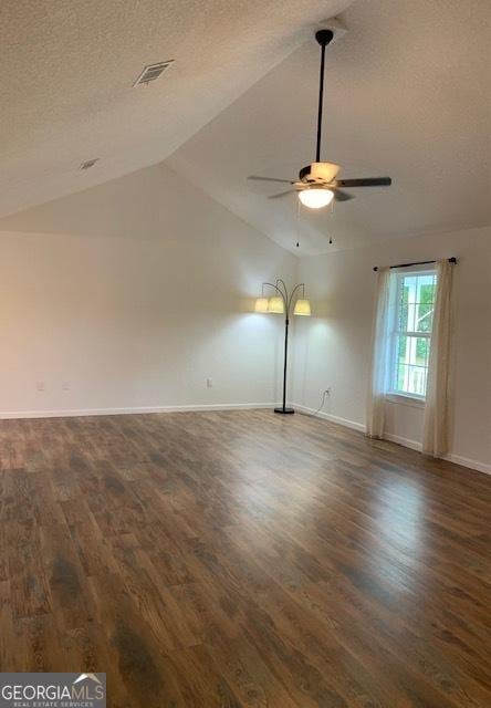 3827 Avant Rd, Blackshear, GA 31516 - spare room featuring a ceiling fan, dark wood-type flooring, baseboards, vaulted ceiling, and a textured ceiling