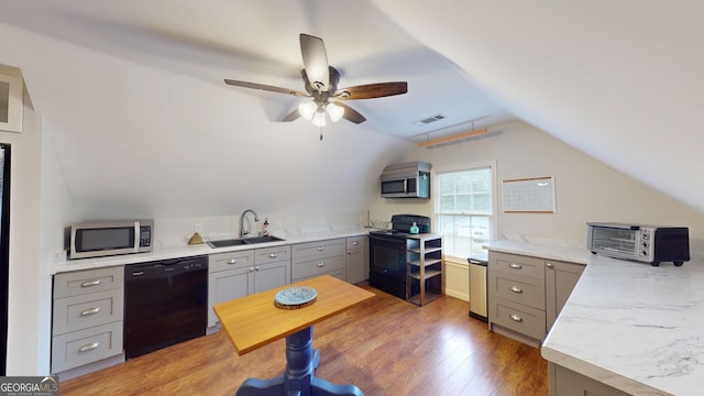 2884 Overwood Ln, Snellville, GA 30078 - kitchen with black appliances, gray cabinets, light countertops, light wood-type flooring, and lofted ceiling