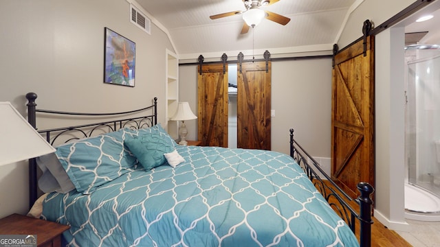 2884 Overwood Ln, Snellville, GA 30078 - bedroom with a barn door, wood finished floors, and a ceiling fan