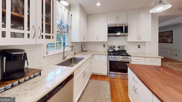 2884 Overwood Ln, Snellville, GA 30078 - kitchen featuring appliances with stainless steel finishes, butcher block countertops, white cabinetry, light wood-style flooring, and recessed lighting
