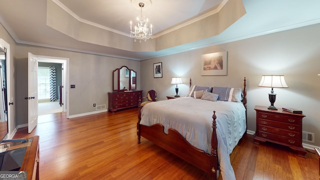 2884 Overwood Ln, Snellville, GA 30078 - bedroom featuring a chandelier, wood finished floors, crown molding, and a tray ceiling