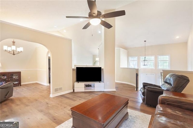2577 Abbotts Glen Dr NW, Acworth, GA 30101 - living room featuring a chandelier, arched walkways, lofted ceiling, and light wood finished floors