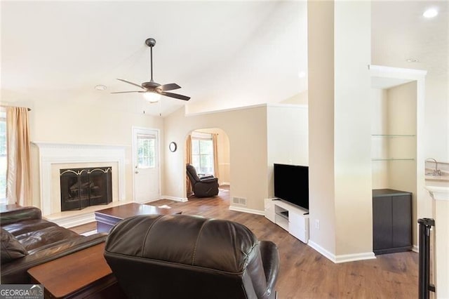 2577 Abbotts Glen Dr NW, Acworth, GA 30101 - living area featuring ceiling fan, wood finished floors, arched walkways, lofted ceiling, and a fireplace with raised hearth