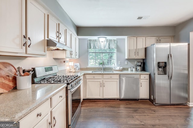 5548 Fitzpatrick Trce, Peachtree Corners, GA 30092 - kitchen with appliances with stainless steel finishes, under cabinet range hood, a sink, dark wood finished floors, and light stone countertops
