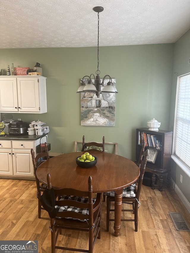 65 Barclay Ct, Newnan, GA 30263 - dining space featuring light wood-style floors, a chandelier, and a textured ceiling