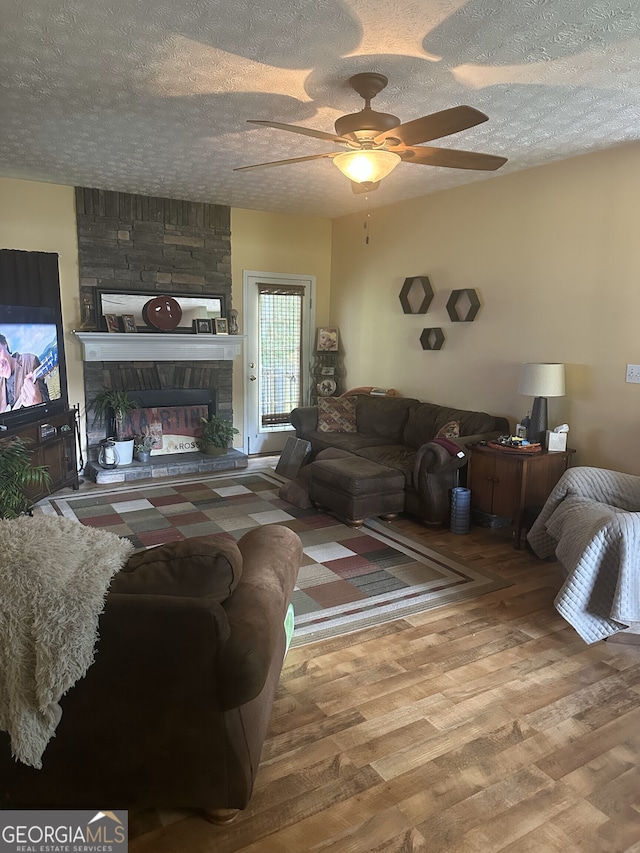 65 Barclay Ct, Newnan, GA 30263 - living area featuring a ceiling fan, wood finished floors, a textured ceiling, and a fireplace