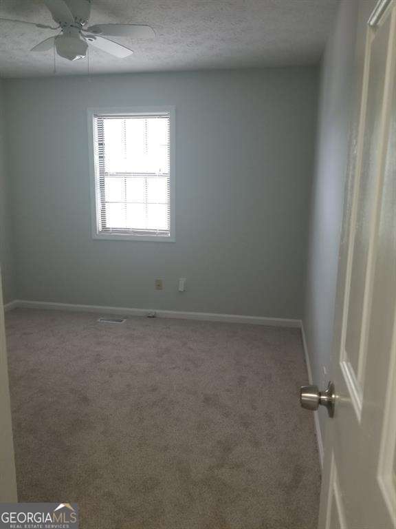 3530 Hopkins Ct, Powder Springs, GA 30127 - carpeted spare room featuring baseboards, a ceiling fan, and a textured ceiling