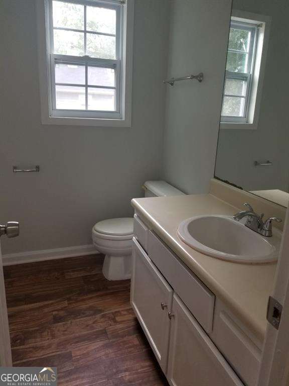 3530 Hopkins Ct, Powder Springs, GA 30127 - bathroom featuring toilet, vanity, wood finished floors, and baseboards