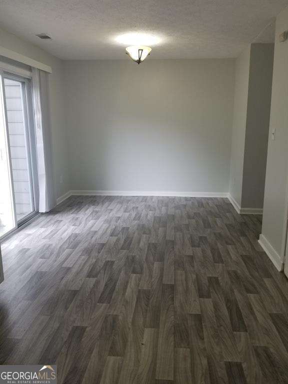 3530 Hopkins Ct, Powder Springs, GA 30127 - unfurnished room with dark wood-style flooring, a textured ceiling, and baseboards
