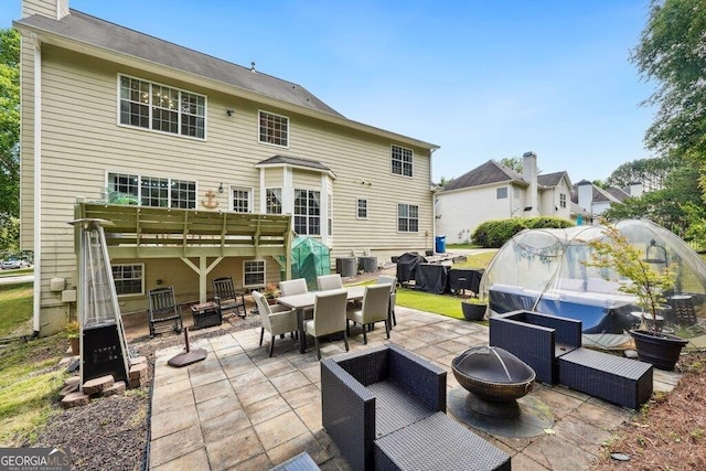 4630 Smokestone Dr, Douglasville, GA 30135 - back of house featuring a patio area, outdoor dining space, a chimney, and an outdoor living space with a fire pit